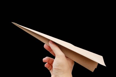 Elinde siyah arka plan üzerine izole kahverengi uçak roket kağıt