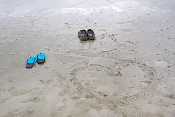 夏の日の海で砂の上塗装ハートとビーチでカップル靴 — ストック写真