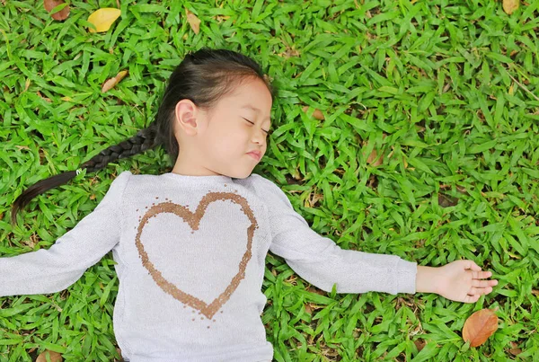 Feliz Bonito Pequena Menina Asiática Deitada Gramado Verde Sorrindo Fechando — Fotografia de Stock