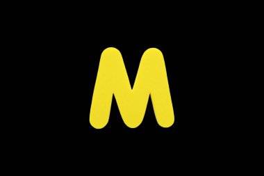 Alfabe harf M sembolü sünger siyah arka plan üzerinde izole kauçuk.