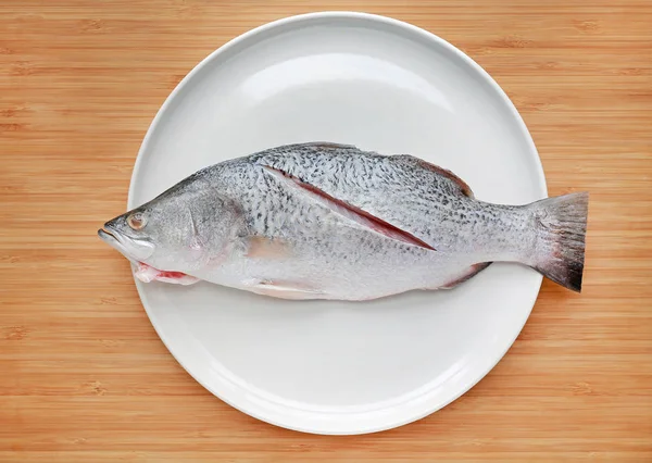 Ikan Kakap Putih Segar Piring Putih Dengan Latar Belakang Papan — Stok Foto
