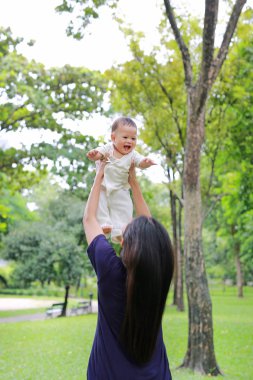 Asya Anne mutlu bebek bebek çocuk bahçesinde silah atar.
