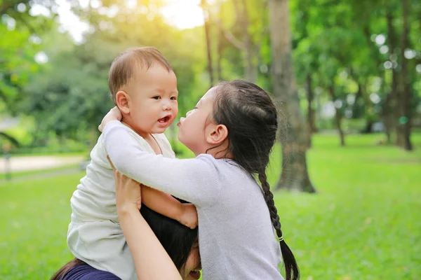 Close Bebé Niño Cabalgando Hombro Mamá Con Hermana Besándose Parque —  Fotos de Stock