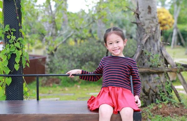 Menina Asiática Pequena Feliz Sentada Banco Madeira Jardim Público — Fotografia de Stock