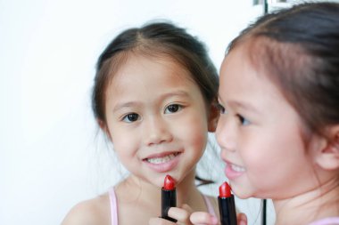 Sevimli küçük çocuk kız ruj ayna önünde uygulamaya hazır.