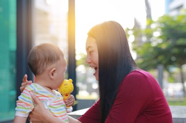 Onun bebek bebek çocuk açık oynayan genç Asya Anne.