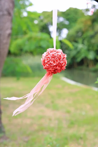 Bush of decoration artificial rose hanging in the nature park. Wedding decorative in the green garden outdoor.