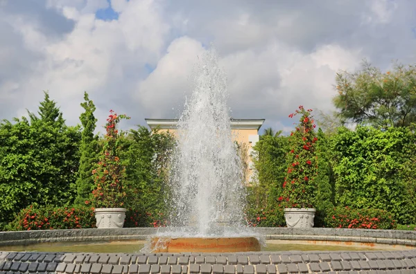 Beautiful fountain in the flower garden.