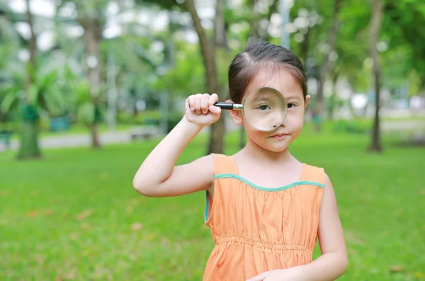 Pequena Menina Asiática Olhando Através Lupa Sobre Grama Livre — Fotografia de Stock