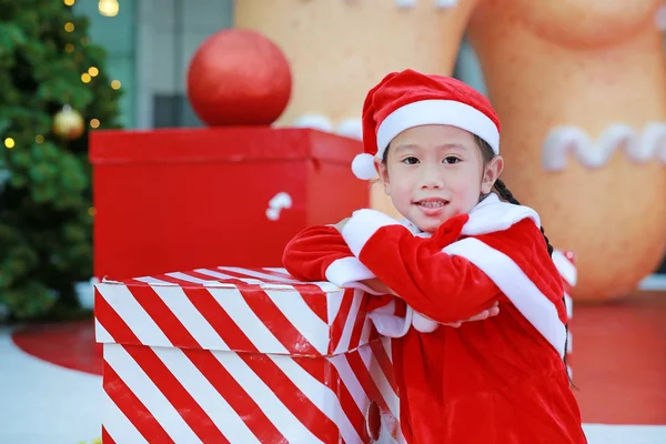 快乐可爱可爱的亚洲小女孩在圣诞老人服装与礼品盒附近的圣诞树和背景 圣诞节寒假概念 — 图库照片