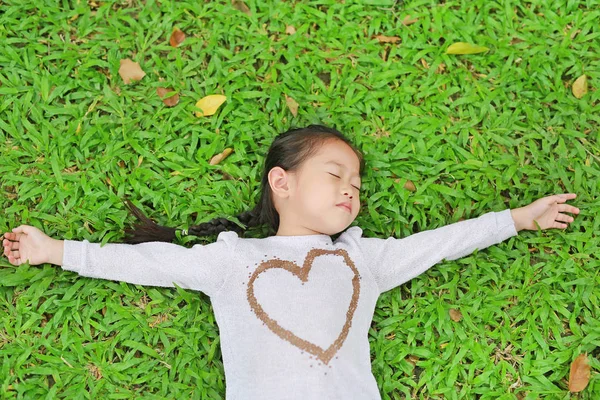 Zadowolony Ładny Asian Dziecko Dziewczynka Leżąc Zielony Trawnik Uśmiechając Się — Zdjęcie stockowe