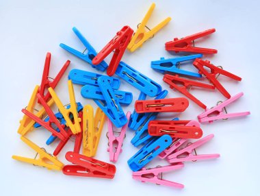 Beyaz arka plan üzerinde renkli plastik clothespins dönüştürün.