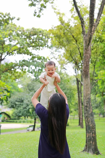 Asya Anne mutlu bebek bebek çocuk bahçesinde silah atar.