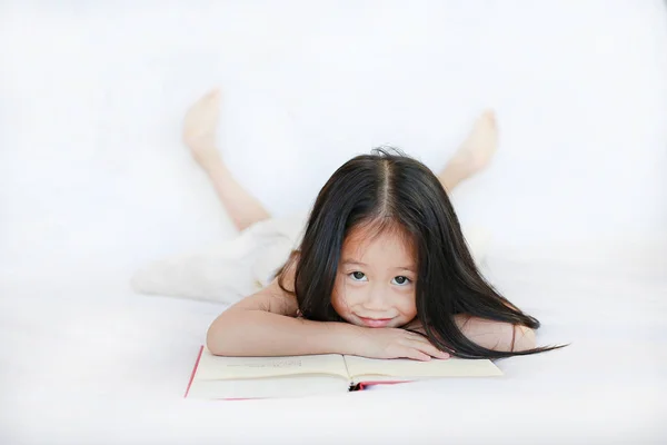 Sorrindo Pequena Menina Asiática Com Capa Dura Livro Deitado Cama — Fotografia de Stock