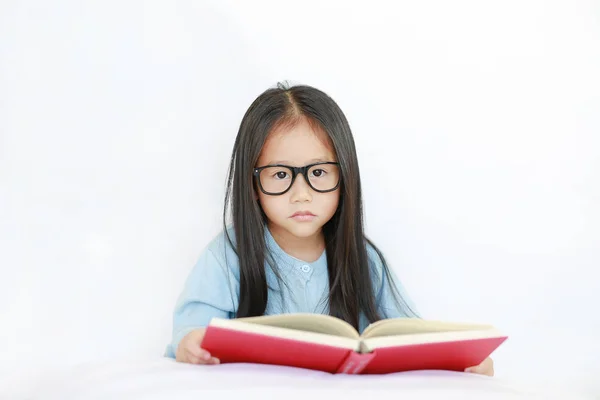 Милая Маленькая Азиатская Девочка Очках Читает Книгу Твердом Переплете Лежащую — стоковое фото