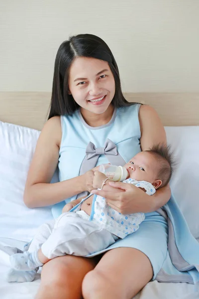 Hermosa Asiático Madre Alimentación Leche Bebé Por Biberón Cama —  Fotos de Stock