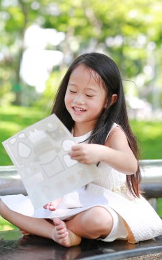 Çıkartmalar yeşil parkta oynarken mutlu küçük Asyalı çocuk kız.