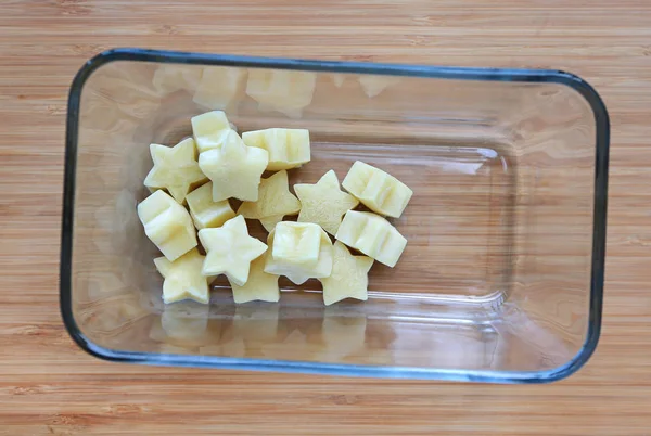 木の板の正方形のガラスのボウルにレタス キューブから冷凍赤ちゃん食品自家製の黄色い星 — ストック写真