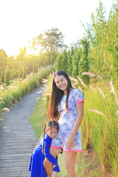 早晨日出时在草地上快乐的亚洲母亲和女儿 — 图库照片