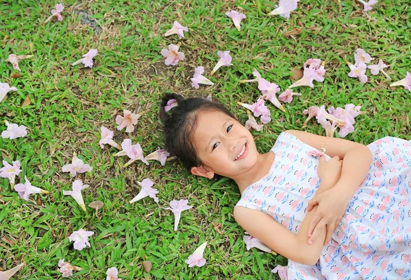 Menina Feliz Deitado Grama Verde Com Queda Flor Rosa Jardim — Fotografia de Stock