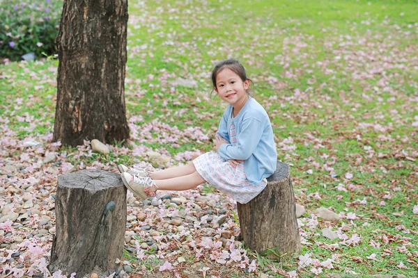 Feliz Niña Sentada Troncos Madera Contra Caída Flor Rosa Jardín —  Fotos de Stock