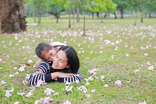 Fröhliches Kindermädchen Kuschelt Ihre Mutter Auf Der Grünen Wiese Liegend — Stockfoto