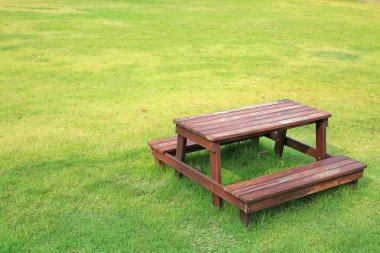 Ahşap masa ve sandalyeler bahçede yeşil çim üzerinde ayarla.