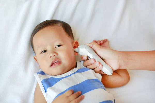 Madre Toma Temperatura Para Bebé Con Termómetro Oído Cama Casa —  Fotos de Stock