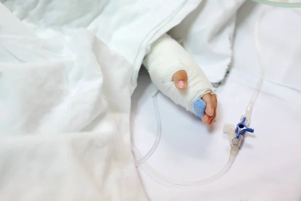 Feche Mão Bebê Cama Paciente Hospital Com Solução Salina Intravenosa — Fotografia de Stock