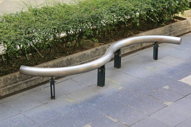 Yaprak duvara karşı otobüs durağında Modern metal tezgah