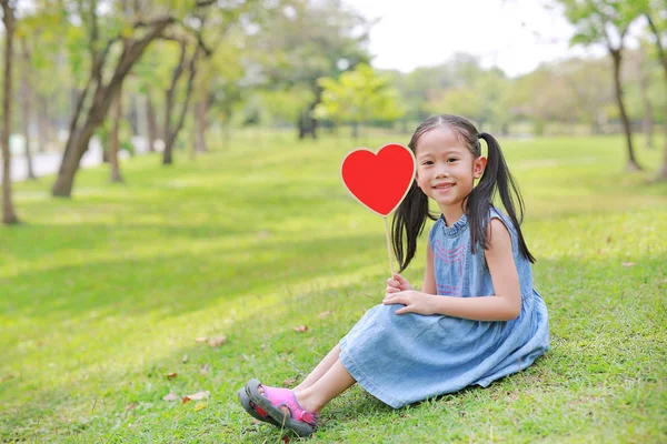 Yeşil Çim Üzerinde Oturan Boş Kalp Etiketi Tutan Sevimli Küçük — Stok fotoğraf