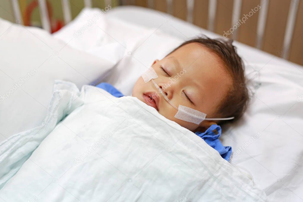 Close up Baby boy on patient bed with tube in nose to deliver oxygen. Respiratory support.