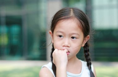Çocuk kız parmaklarını emme niyetinde. Güven eksikliği çocukların jestleri.