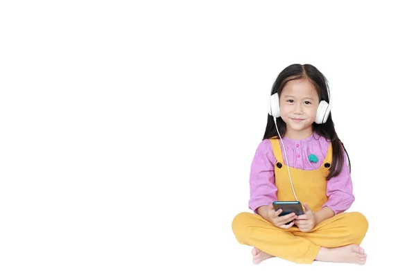 Ευτυχισμένο μικρό κορίτσι απολαμβάνει ακούγοντας μουσική με τα ακουστικά βαλβίδες — Φωτογραφία Αρχείου