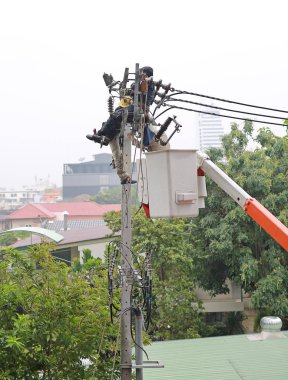 Elektrik direği üzerinde çalışırken dinlenen elektrikçiler.