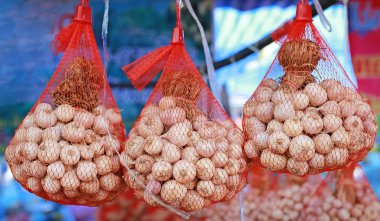 Naylon ağ çantasında asılı kurutulmuş sarımsak.