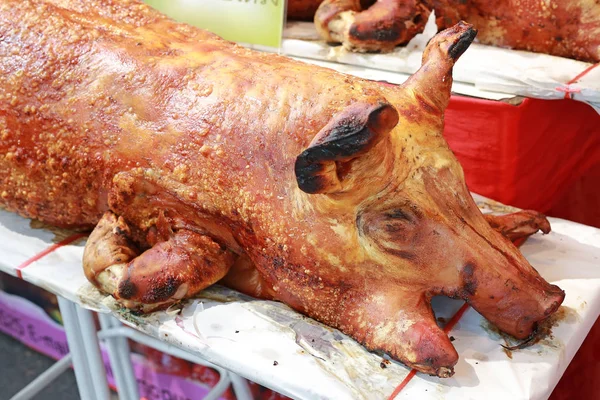 Golden whole roasted pig. Spit roasting is a traditional international luau method of cooking a whole pig.