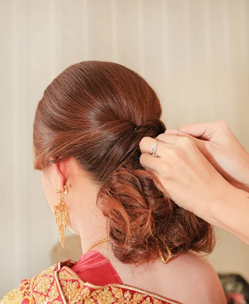 Women\'s hairstyle halo braid on the hair of the brown. Rear view.