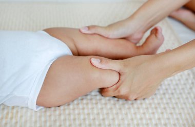 Anne bacak bebek bebek için masaj yapıyor.