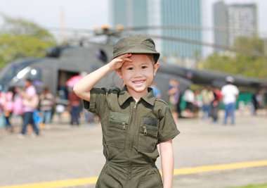 Bulanık helikopter arka plan karşı hava kuvvetleri pilot takım elbise giyen Asyalı çocuk kız portresi.