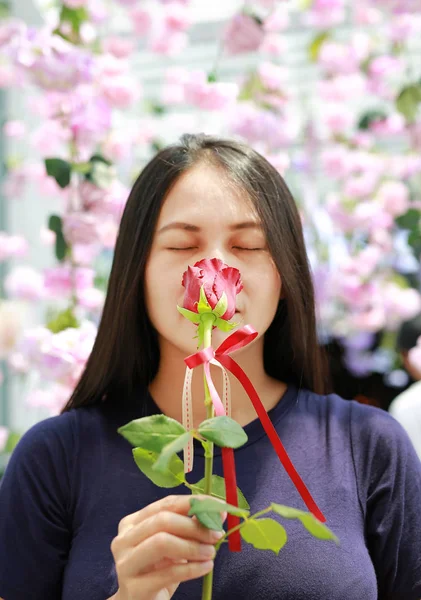 Femme Sentant Une Fleur Rose Entoure Floraison — Photo