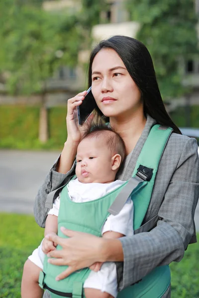 Young Beautiful Businesswoman Talking Mobile Phone While Carrying Her Baby — Stock Photo, Image