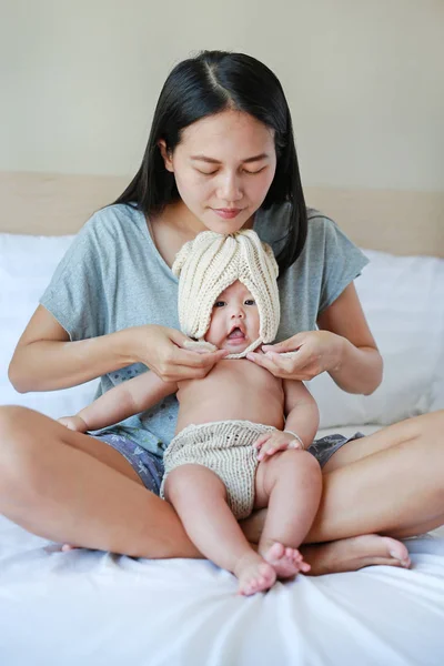 Ibu Mengenakan Beberapa Pakaian Merajut Untuk Bayinya Tempat Tidur — Stok Foto