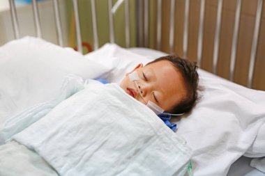 Bebek çocuk yaş yaklaşık 1 yıl yaşlı hasta yatağı üzerinde oksijen oksijen doygunluğu sağlamak için burun dişleri ile getting ile uyuyor. Hastanede yoğun bakımda. Solunum desteği.