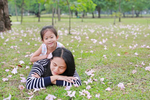 Fröhliches Kindermädchen Kuschelt Ihre Mutter Auf Der Grünen Wiese Liegend — Stockfoto