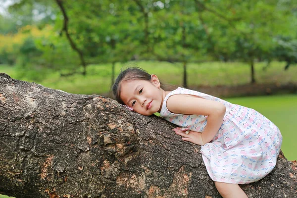 Urocze Małe Dziecko Dziewczynka Wznoszenia Odpoczynku Big Pniu Drzewa Ogrodzie — Zdjęcie stockowe