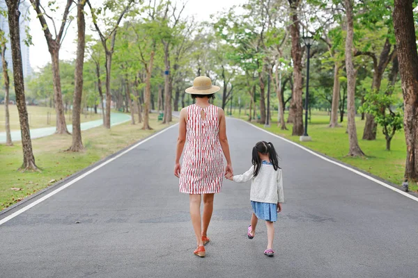 アジアのお母さんと娘は 夏の公園で通りを歩いて 背面図 — ストック写真