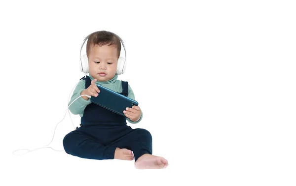 Rozkošný asijský chlapeček rád poslouchá hudbu s headpem — Stock fotografie