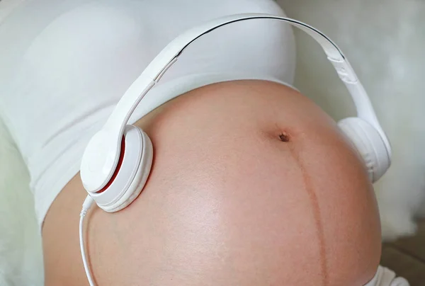 Mãos Mulher Grávida Segurando Fone Ouvido Colocando Fones Ouvido Barriga — Fotografia de Stock