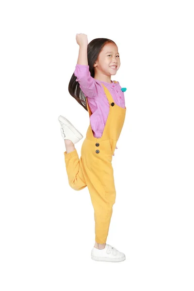 Funny little Asian child girl in pink-yellow dungarees jumping o — Stock Photo, Image